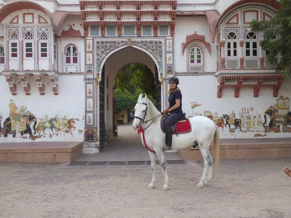 Horse safari riders crossing the rural landscape near Rohet Garh in Rajasthan, India